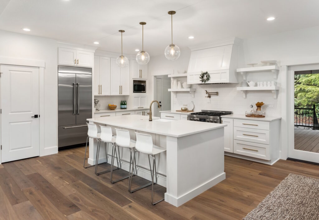 Kitchen Remodel with new wooden floors, white lower cabinets, open shelves, large island with sink, and stainless steel appliances, CK Contracting, Custom Home Remodeling, Mt. Pleasant, S.C.