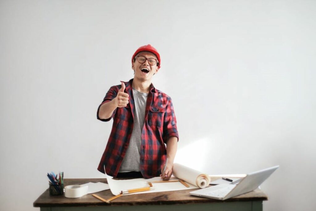 A Contractor standing at a desk, giving a thumbs up - Ck Contracting - General Contractor - Mount Pleasant, SC.