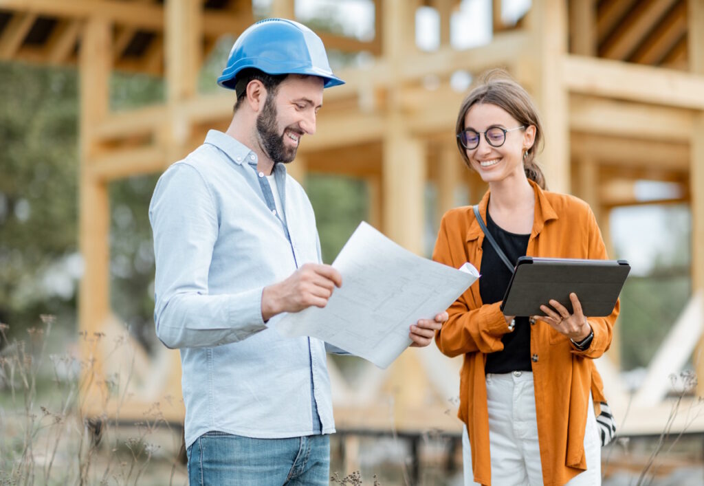 A female homeowner is standing next to the general contractor, holding the home renovation plans, CK Contracting, Custom Home Remodeling, Mt. Pleasant, SC